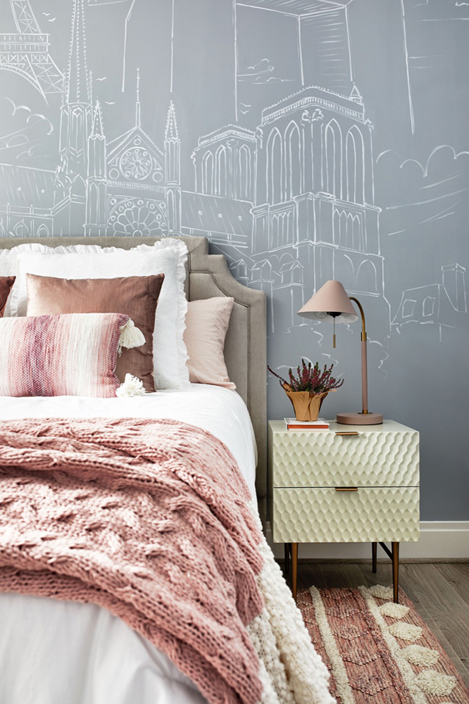 Designed by Christie Leu Interiors, the bedrooms in this Rockville, Maryland home were styled to inspire the young people that would be staying there. This bedroom has a Paris-themed wall design inspired by a traveler's sketchbook, and was painted with Golden Paintworks Slow Dry Fluid Acrylics.