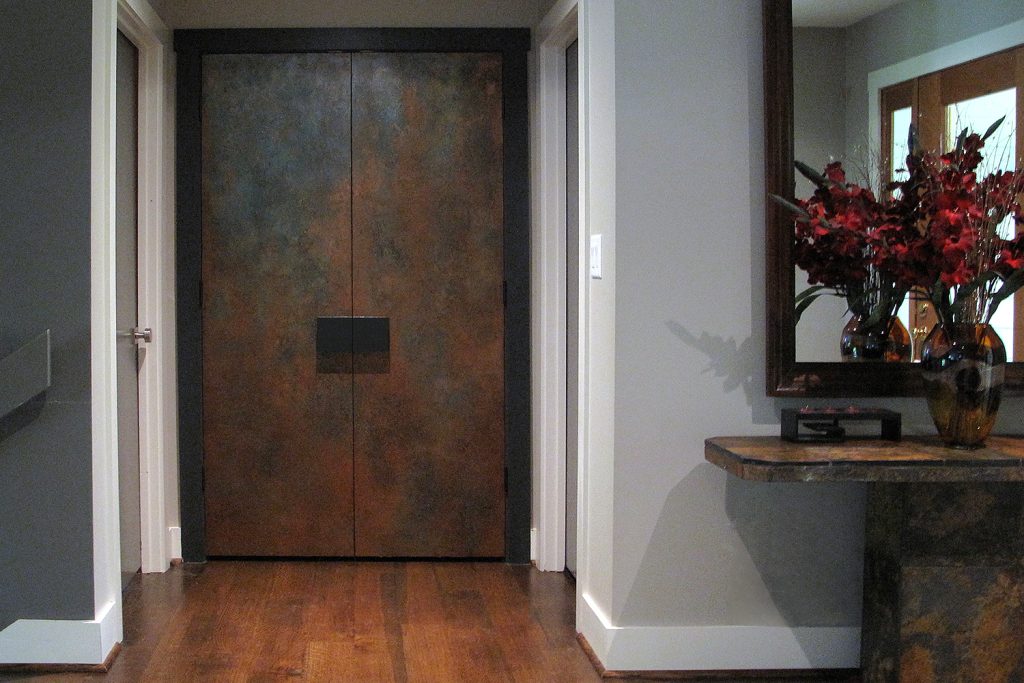 Plain double doors at the end of a hallway become a piece of art that appears like aged copper.  https://kasswilson.com/walk-this-way/