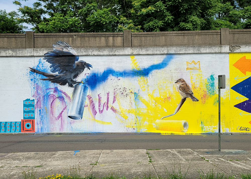 This mural is one of 14 painted along Railroad Avenue for the 2023 Elmira Infinite Canvas Mural Fest.