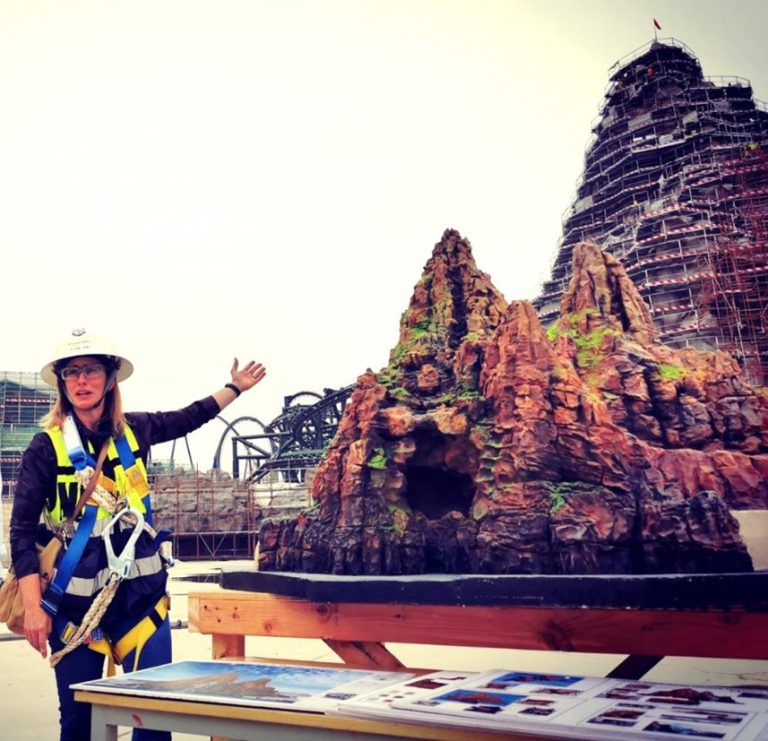 Kirsten with model of mountain and actual rockwork mountain at Universal Beijing Resort’s Jurassic World